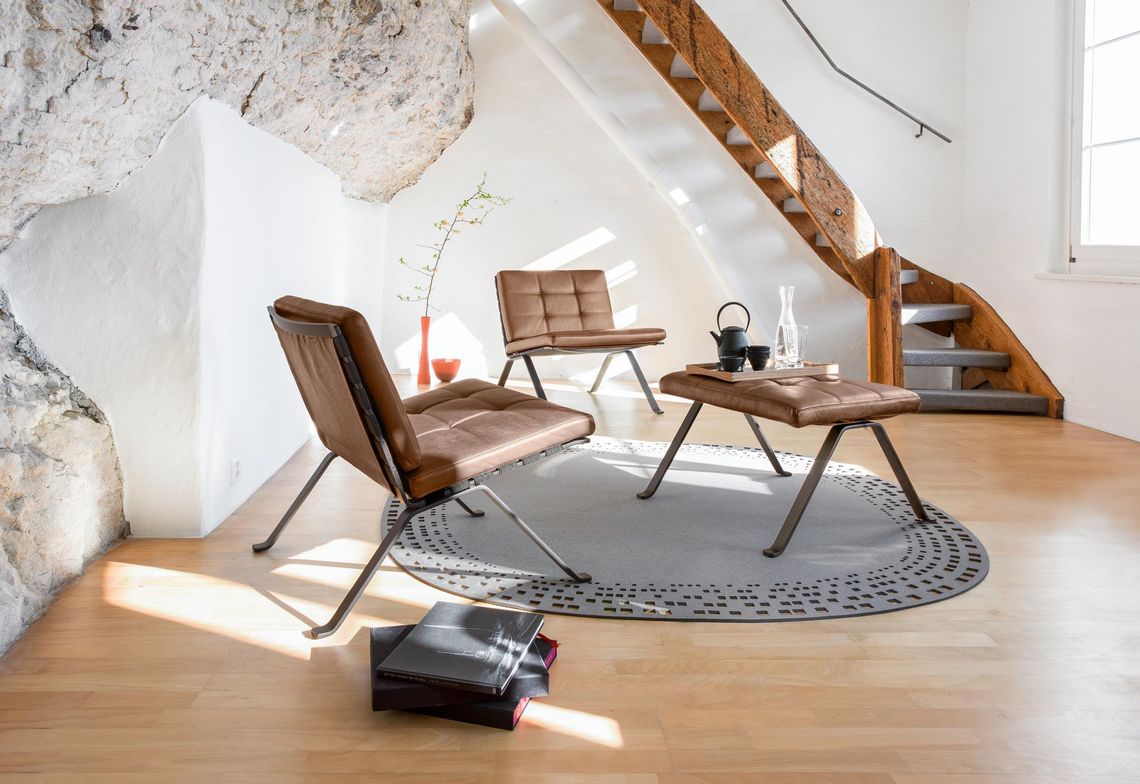 Loungesessel und Polsterhocker in braunem Leder und schwarzem Gestell