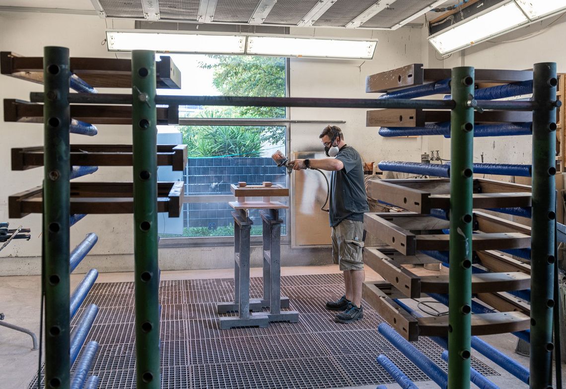 Sanding and varnishing the wooden frames of the riding stables' folding seats