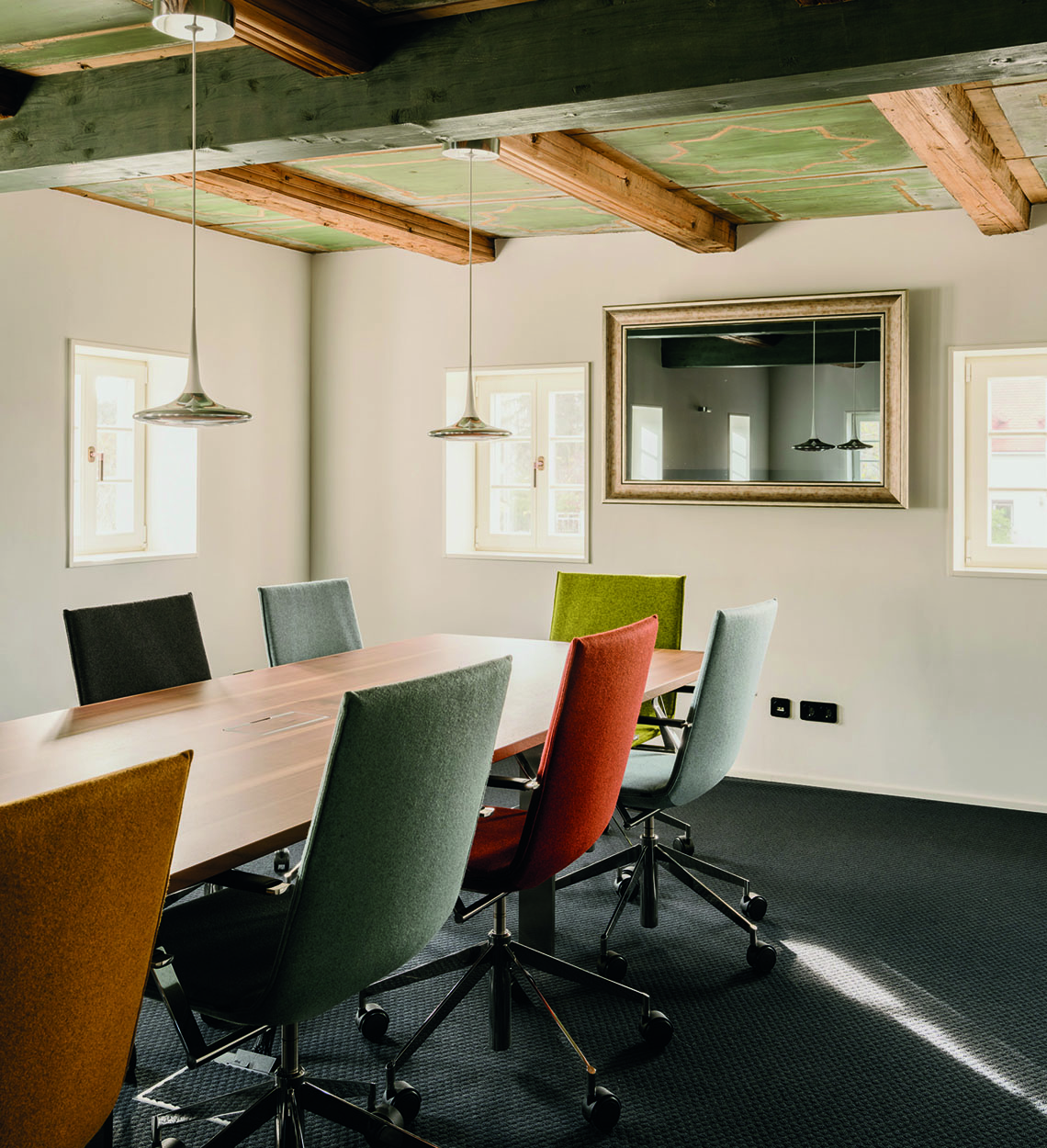 Salle de réunion et de séminaire avec siège pivotant de conférence Jack en différentes versions de couleur autour de la table de conférence Adapt avec clapet multimédia